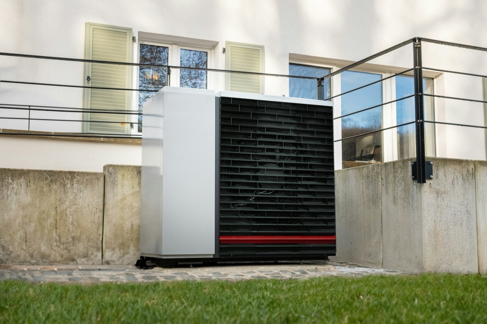 Pompe à chaleur air/eau posée dans le jardin d'une maison