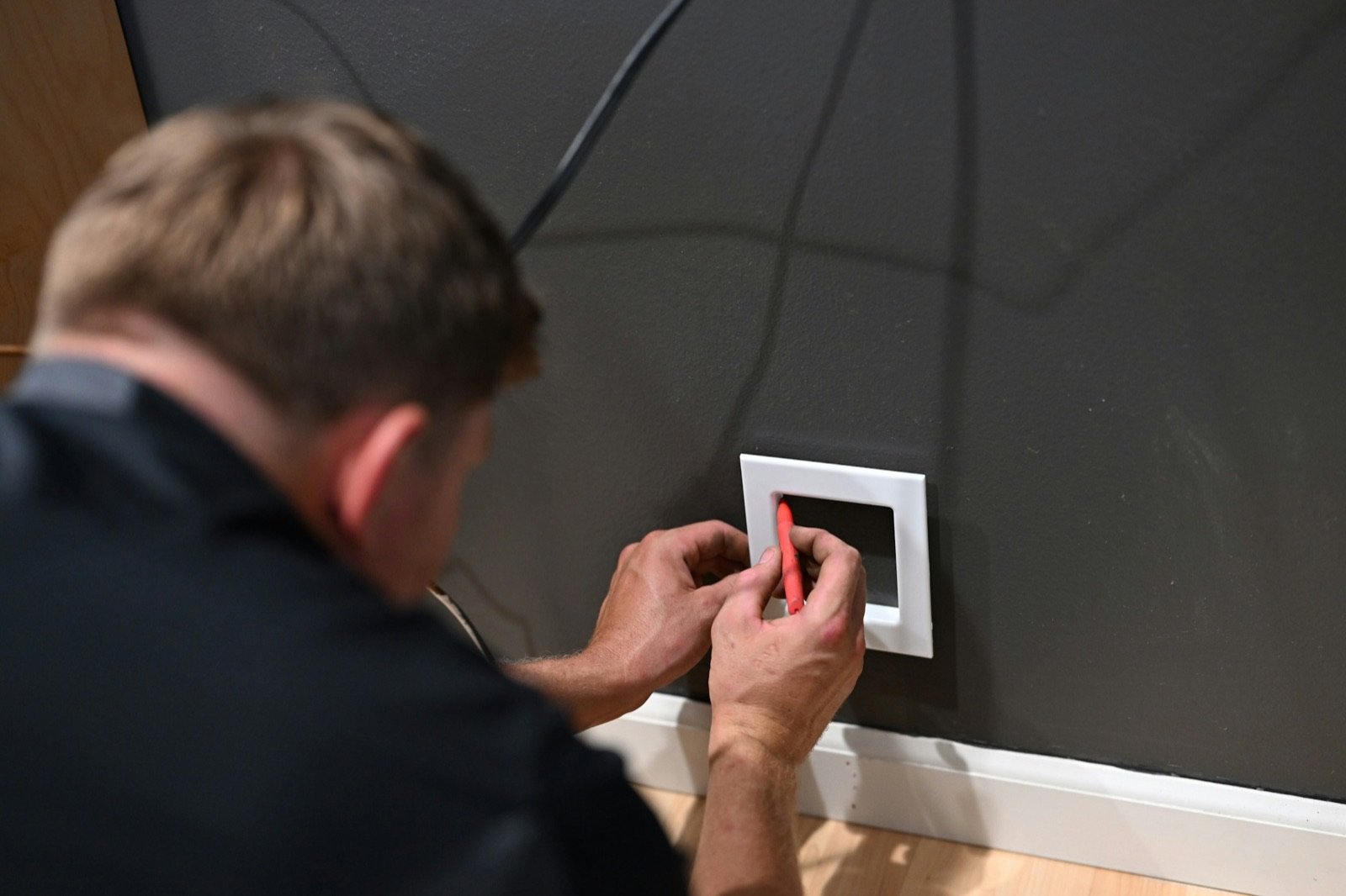 Technicien posant un thermostat au mur